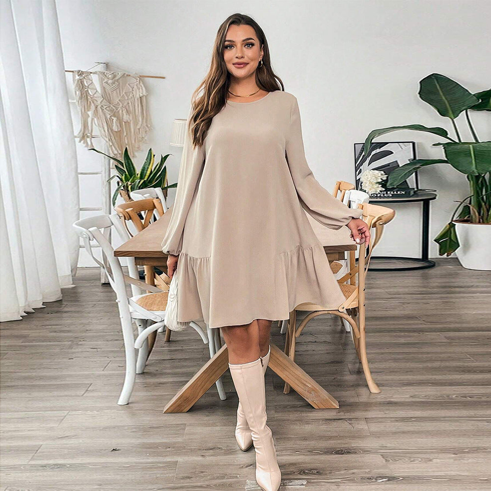 Woman in beige long-sleeved midi dress with ruffled hem and knee-high boots for winter fashion