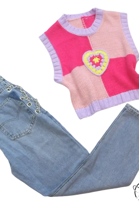 Pink knit vest with crocheted heart on chain straight jeans