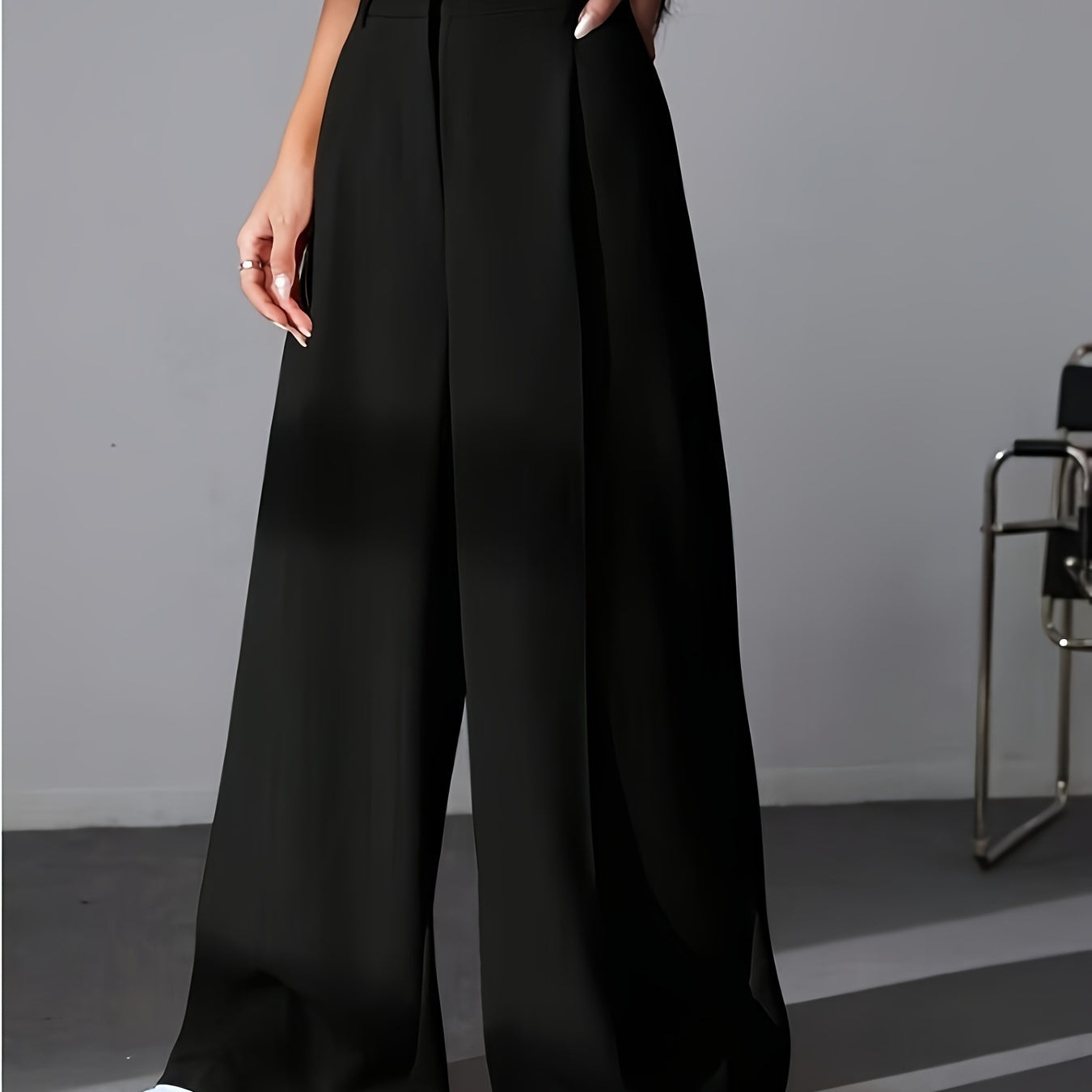 Black wide leg palazzo pants styled with white sneakers for a chic fashion look