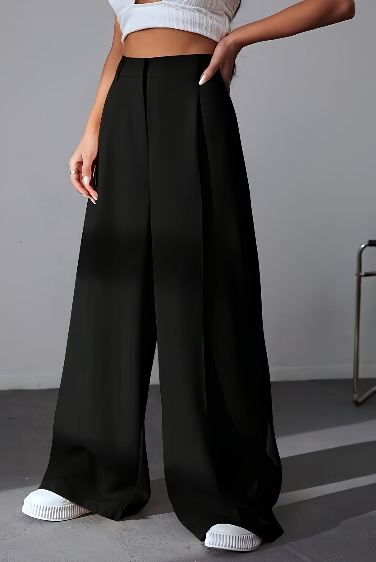 Black wide leg palazzo pants styled with white sneakers for a chic fashion look