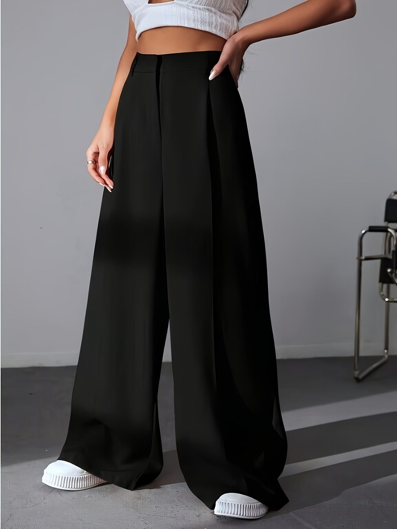 Black wide leg palazzo pants styled with white sneakers for a chic fashion look