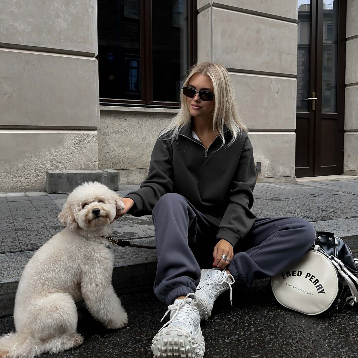 Woman in casual langry fashion wearing fleece lined sweater with a dog outdoors