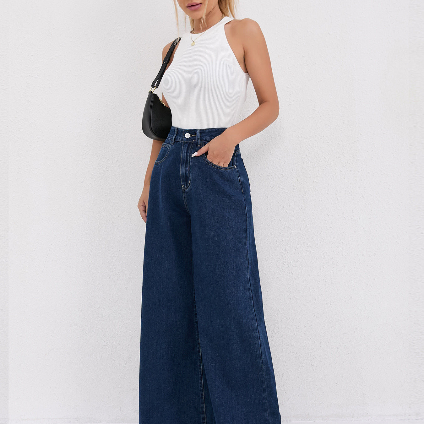 Wide leg dark blue denim jeans paired with a white sleeveless top for modern fashion