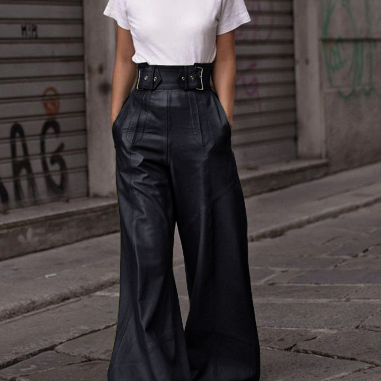 Person wearing white T-shirt and black faux leather bell bottom pants in fashion style