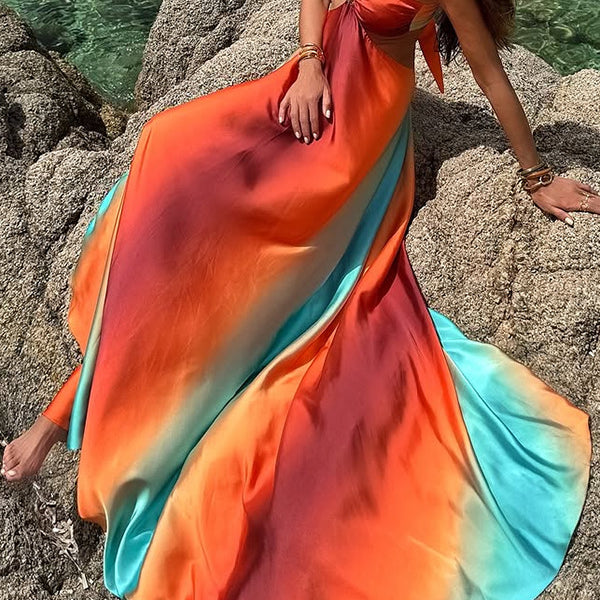 Flowing maxi dress in vibrant orange, red, and turquoise ombré for stylish beach fashion