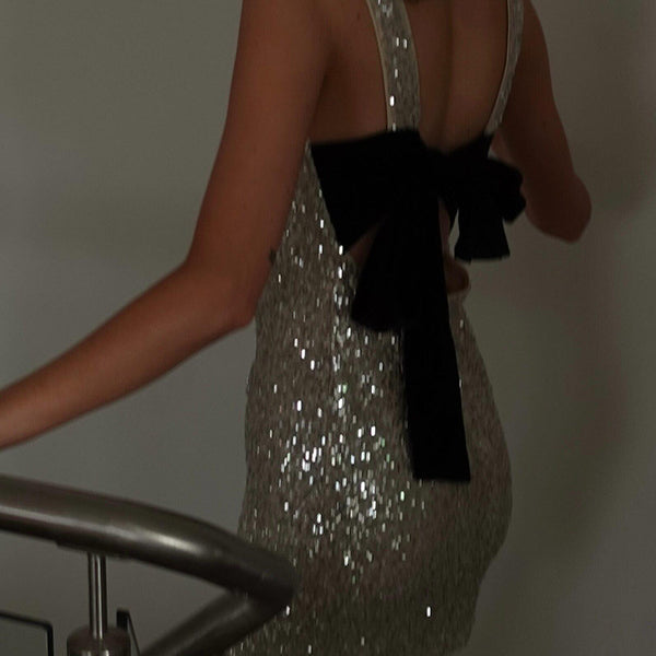 Sparkly silver cocktail dress with black bow, perfect for latest fashion trends in ملابس