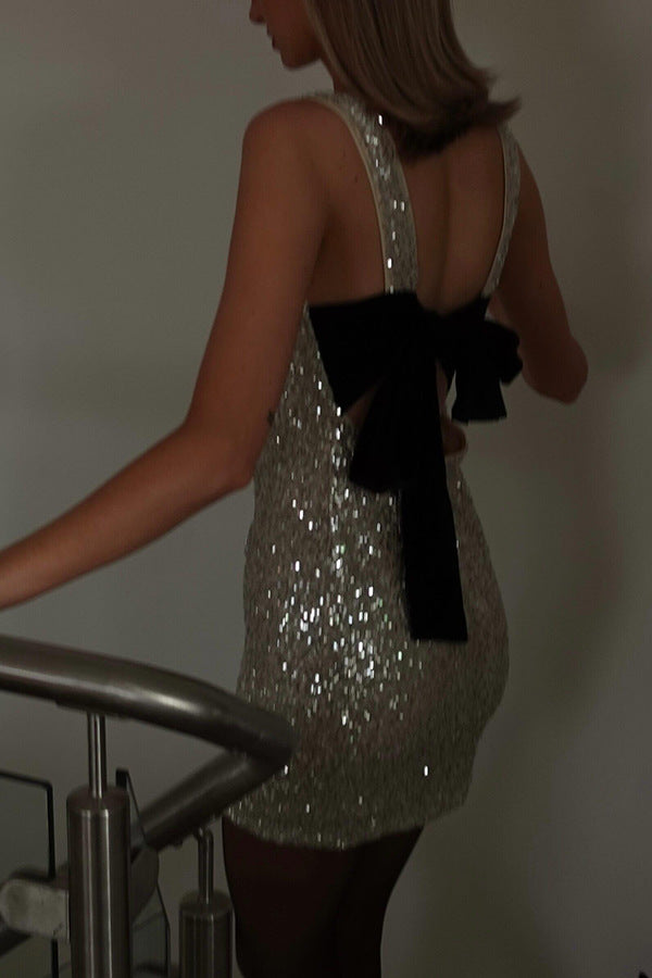 Sparkly silver cocktail dress with black bow, perfect for latest fashion trends in ملابس