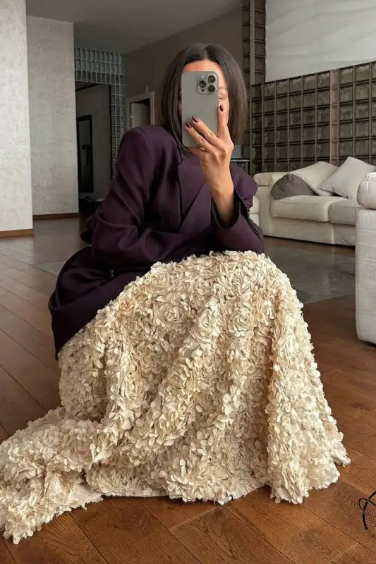 Woman in plum blazer and winter petal design long skirt taking selfie