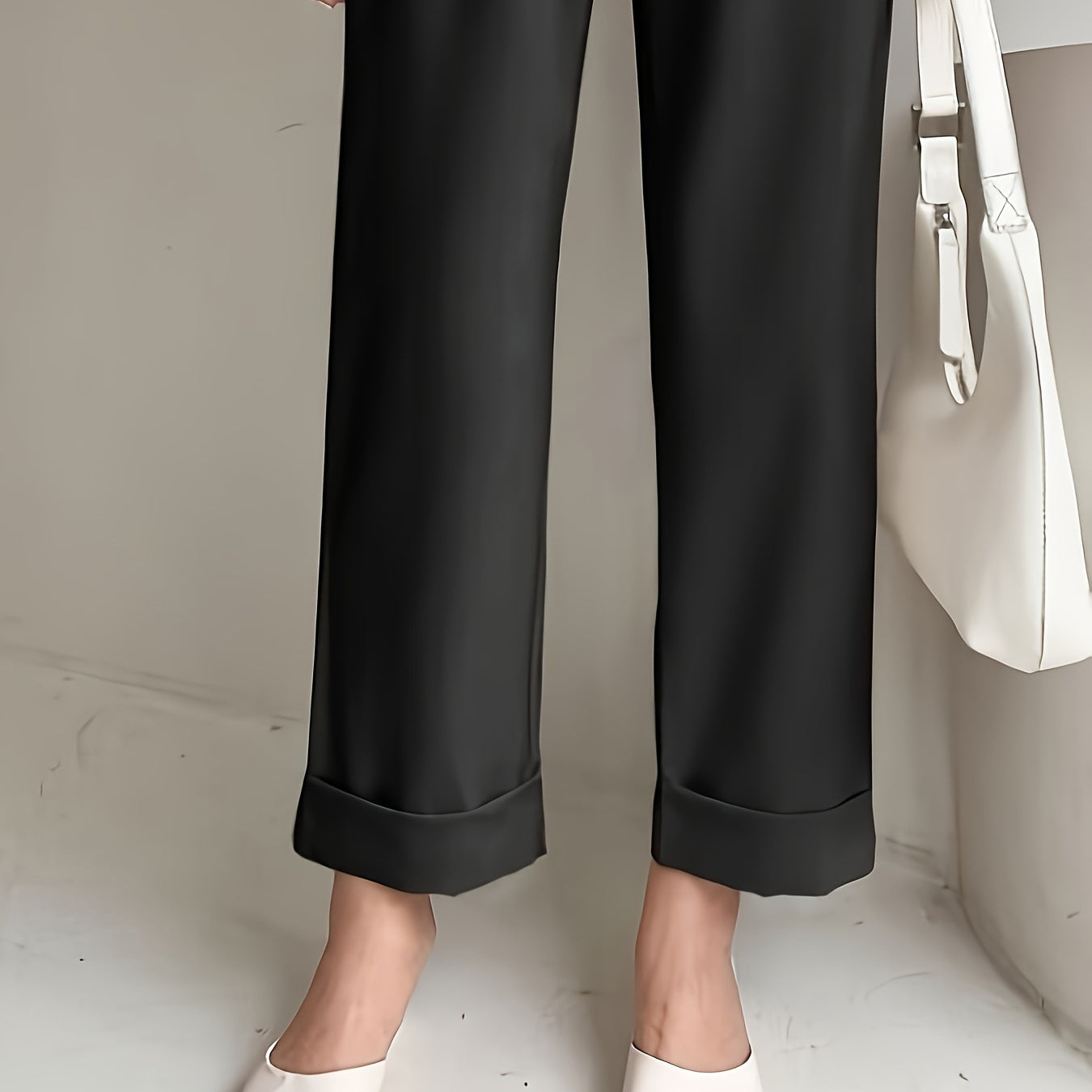 Black wide leg cropped trousers with cuffed hems styled with white pointed flats