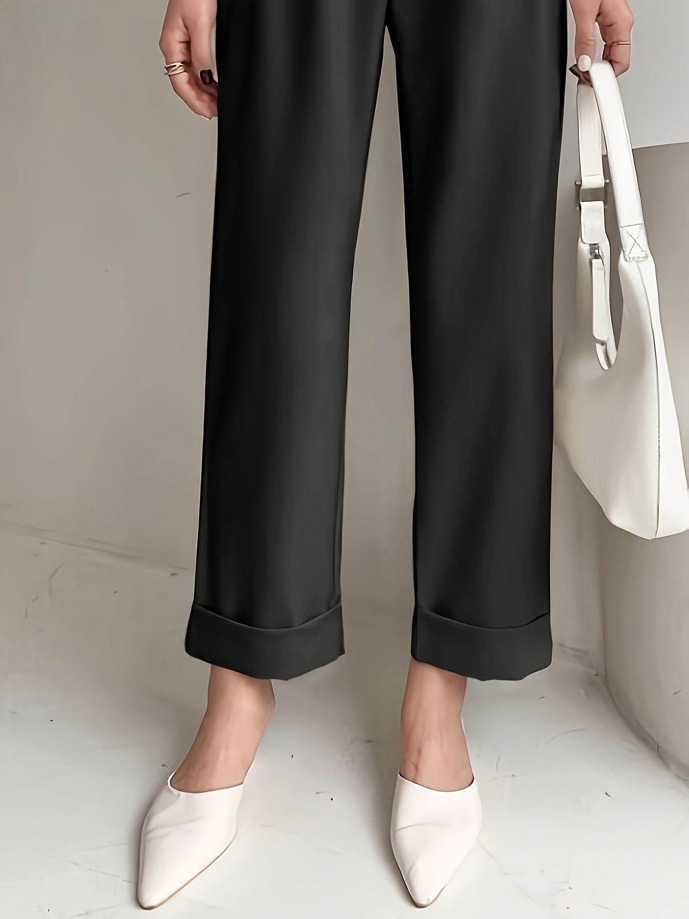 Black wide leg cropped trousers with cuffed hems styled with white pointed flats
