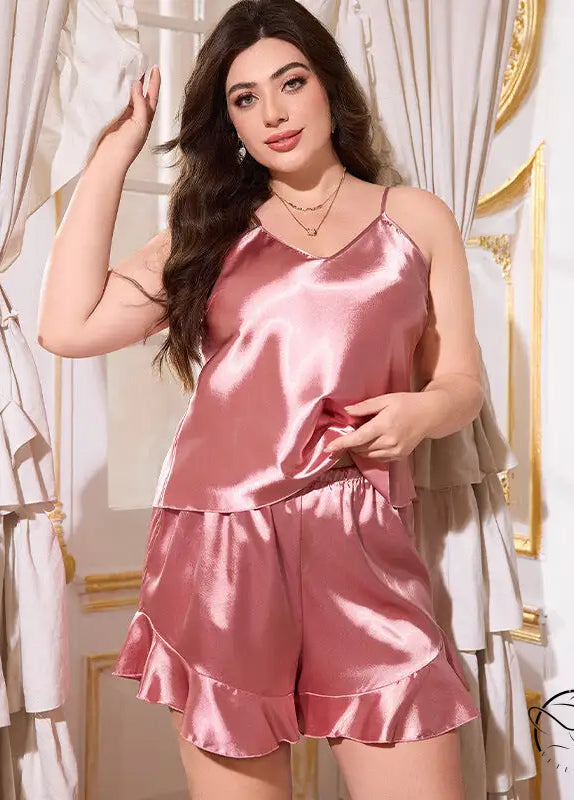 Plus size model in pink satin langry cami shorts set with ruffled hem