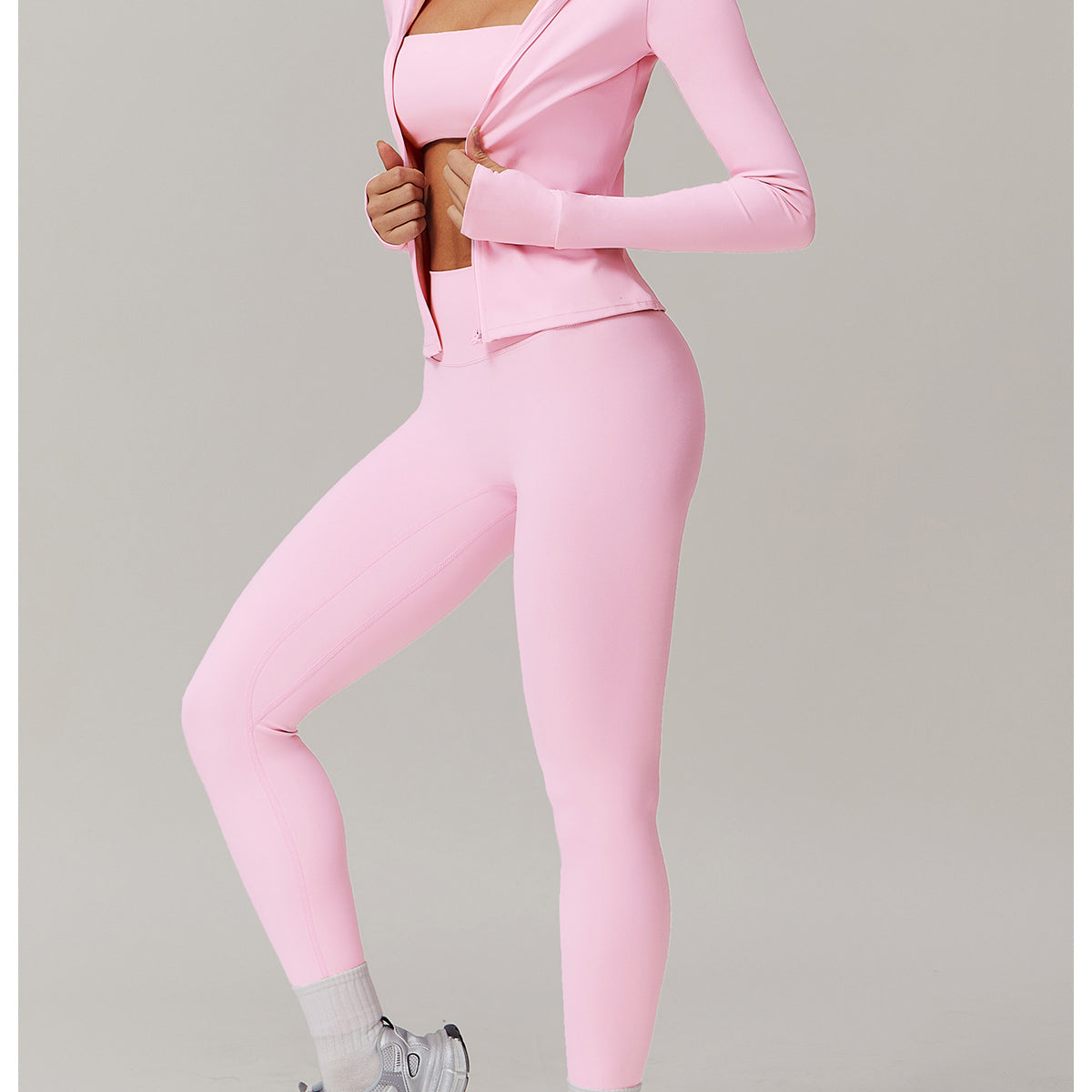 Pink athletic workout set featuring a soft jacket, leggings, and gray sneakers for fashion