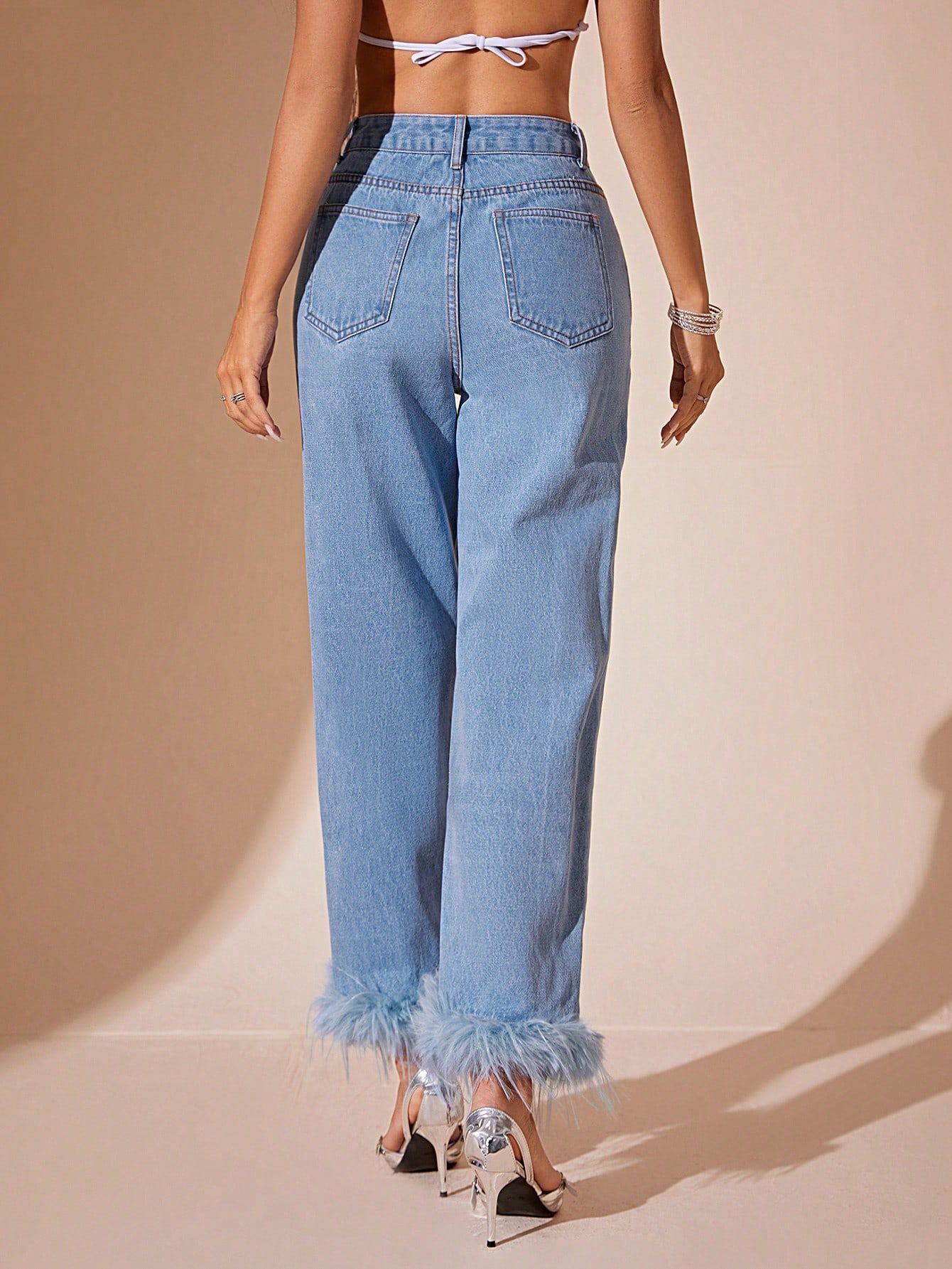 Light blue denim jeans with furry stitching and feather trim on cuffs, straight fit