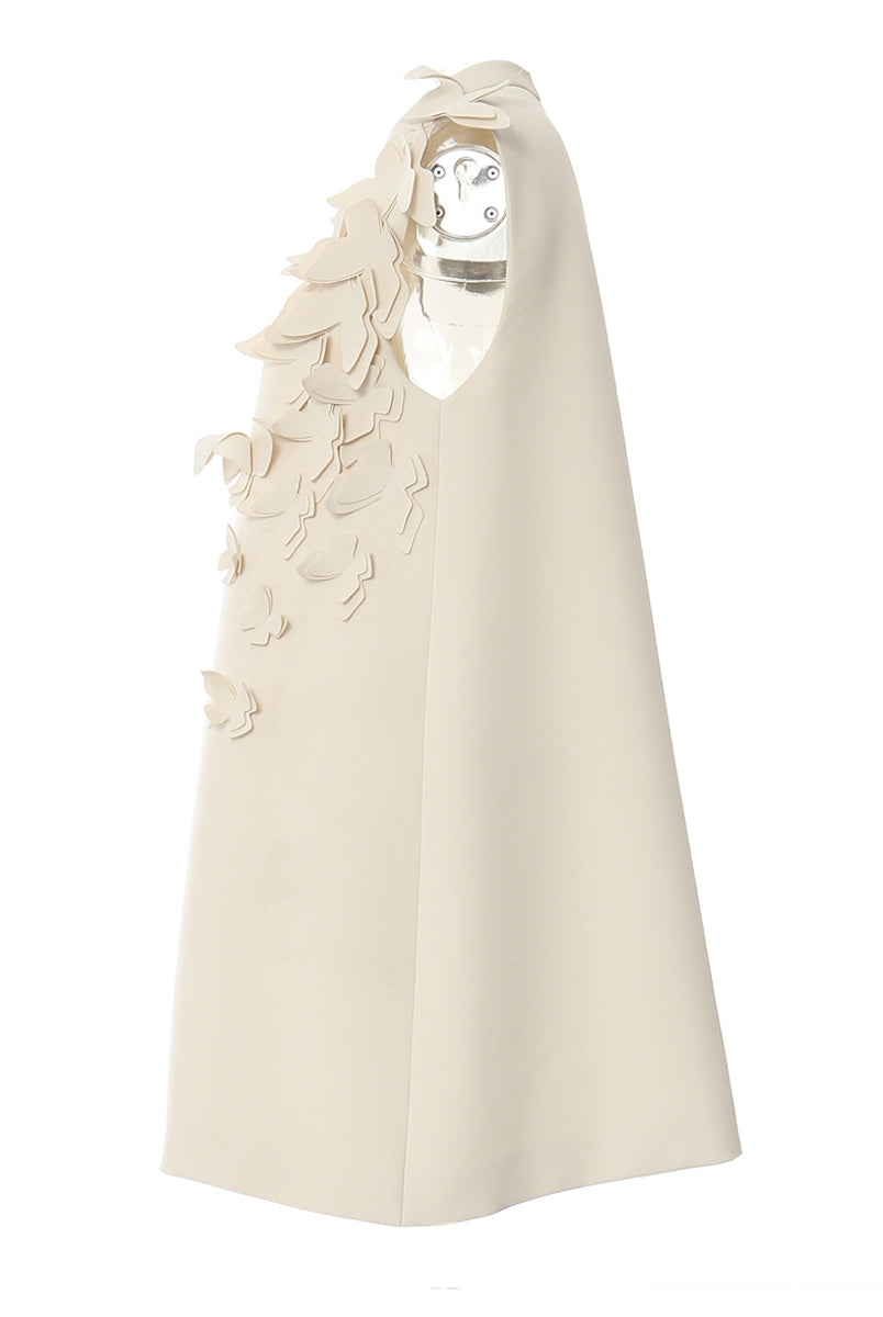 Elegant sleeveless cream-colored dress with butterfly embellishments for winter fashion collection