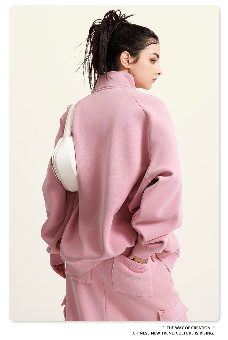 Pink oversized turtleneck sweatshirt paired with a white handbag for winter fashion ملابس