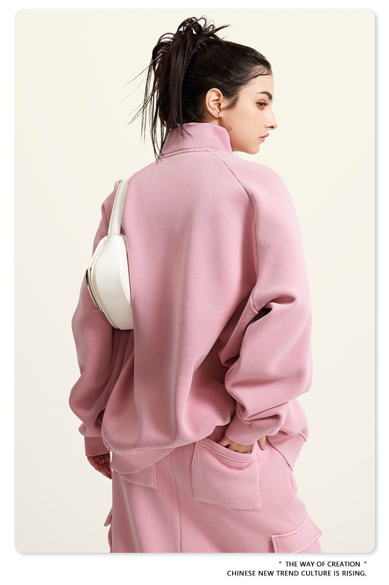 Pink oversized turtleneck sweatshirt paired with a white handbag for winter fashion ملابس