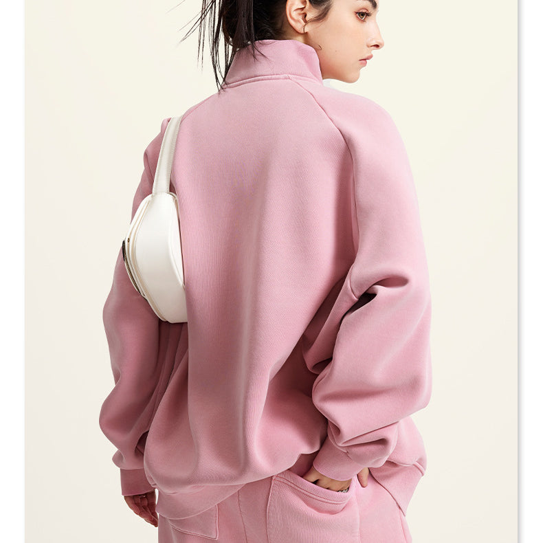 Pink oversized turtleneck sweatshirt paired with a white handbag for winter fashion ملابس