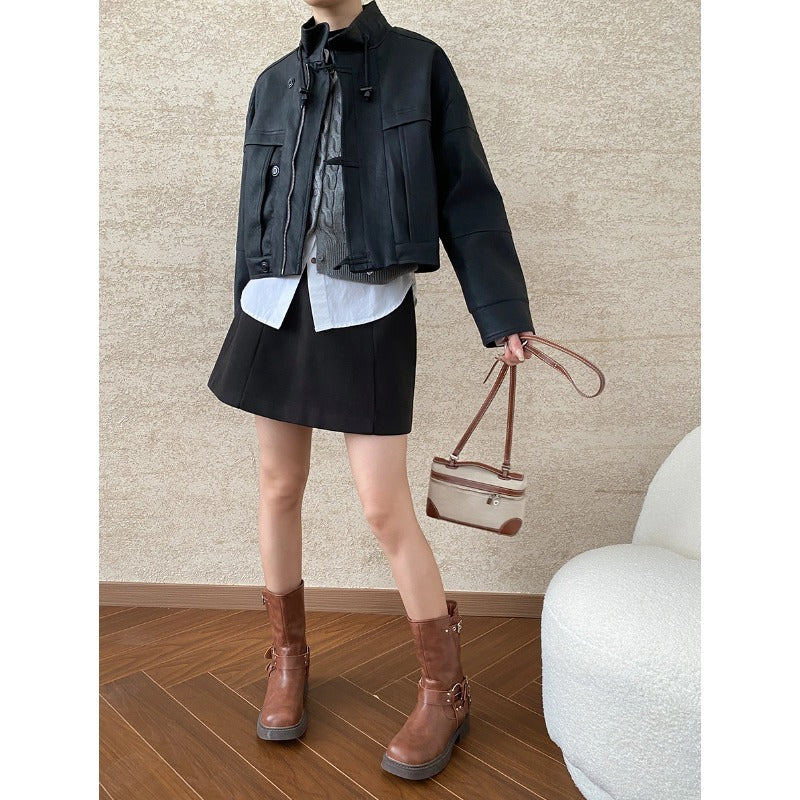 Elegant woman’s outfit with black jacket, skirt, and brown boots showcasing high-quality casual leather coat for fashion enthusiasts