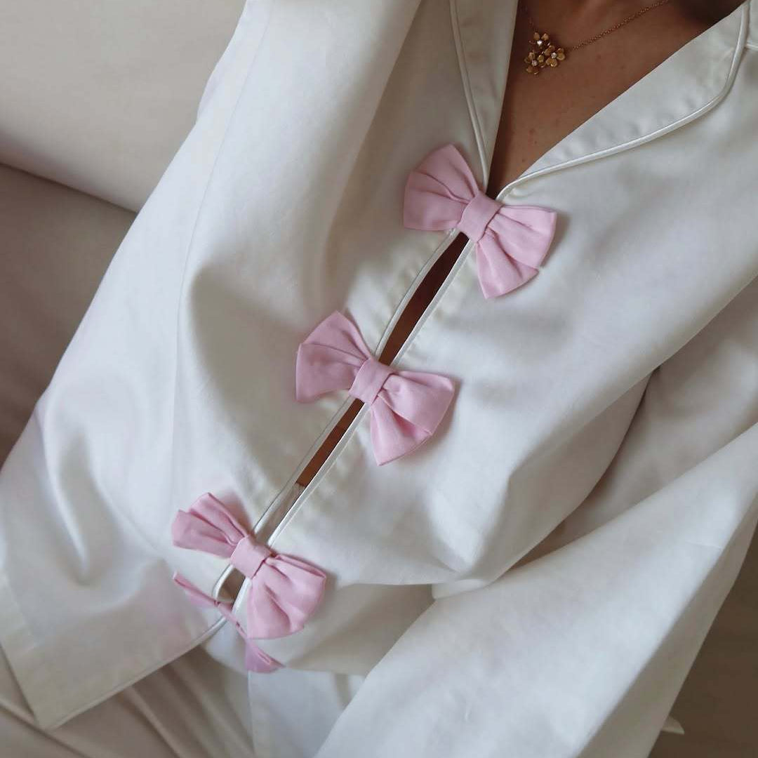 White cotton langry pajama set with pink bow accents and buttons