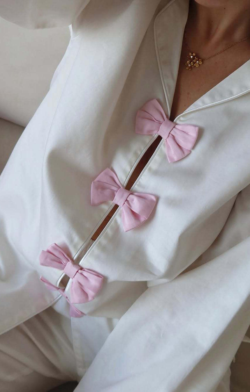 White cotton langry pajama set with pink bow accents and buttons