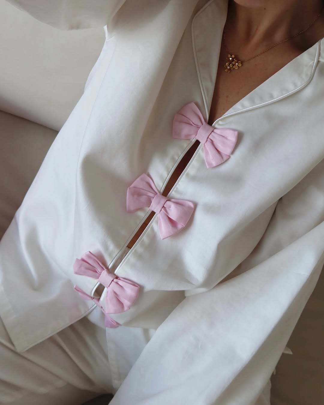 White cotton langry pajama set with pink bow accents and buttons