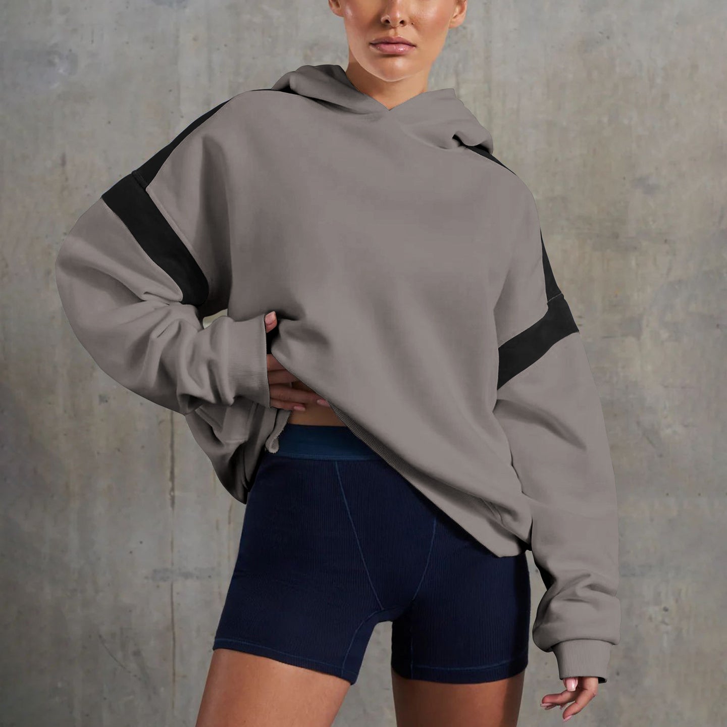 Woman in oversized hoodie and shorts showcasing high-end fashion ملابس
