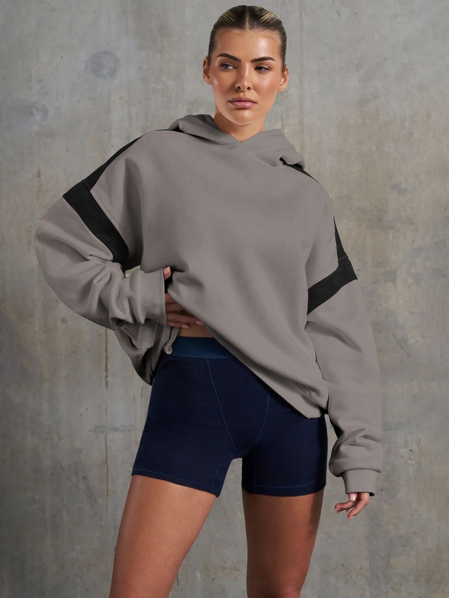 Woman in oversized hoodie and shorts showcasing high-end fashion ملابس