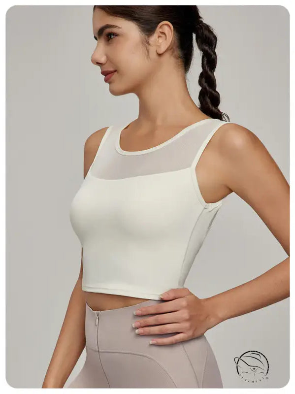 Woman in cream athletic crop top with mesh yoke, Beauty Back Mesh Workout Top