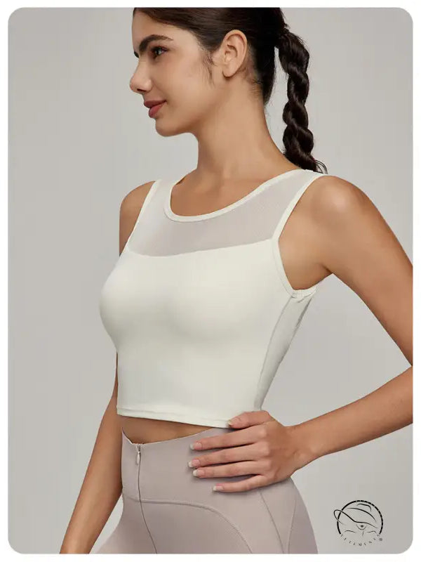 Woman in cream athletic crop top with mesh yoke, Beauty Back Mesh Workout Top