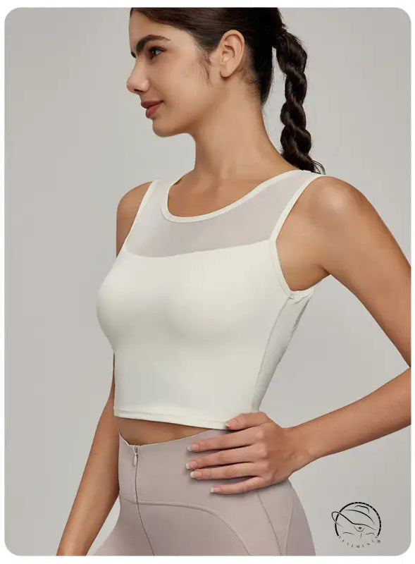 Woman in cream athletic crop top with mesh yoke, Beauty Back Mesh Workout Top