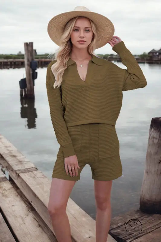 Woman in loose stylish shorts knitting set and straw hat