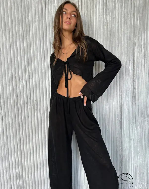 Woman in black casual loose pajamas: tie-front crop top and wide-leg pants