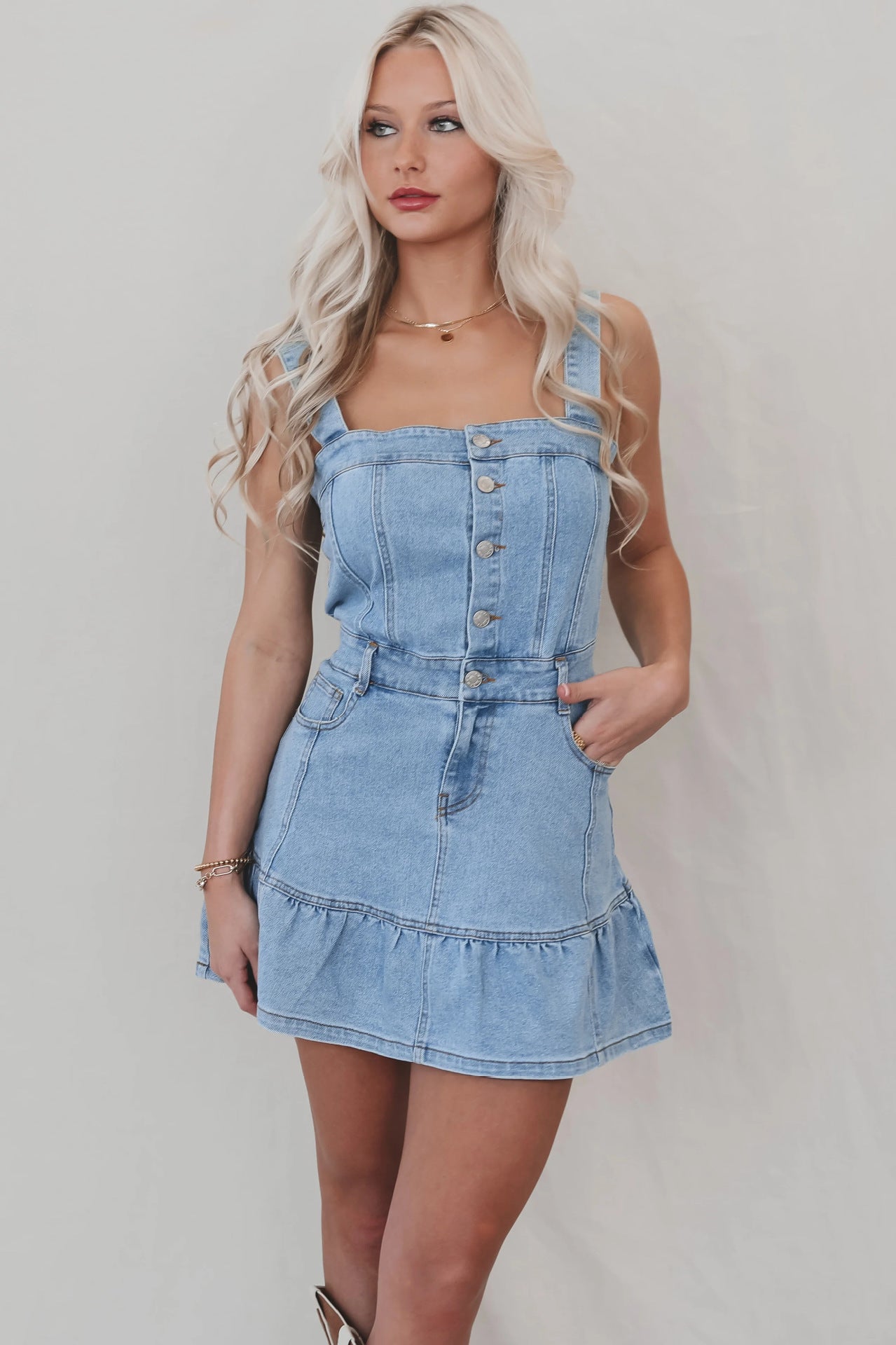 Light-wash denim mini dress with button-front bodice and ruffled hem, ideal for office suspenders denim style