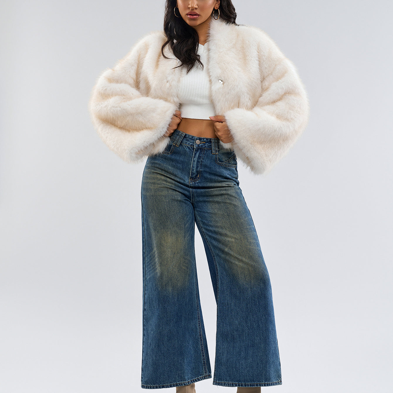 Woman in a langry faux fur coat with wide-leg jeans and ankle boots, trendy ملابس fashion