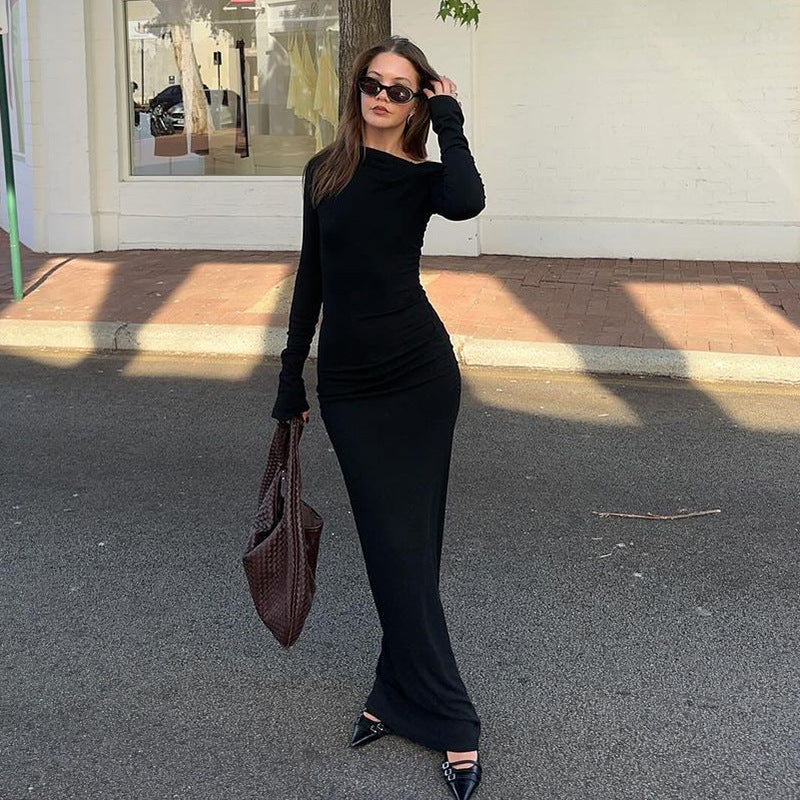 Elegant long-sleeved black maxi dress with fitted silhouette, ideal for fashion enthusiasts