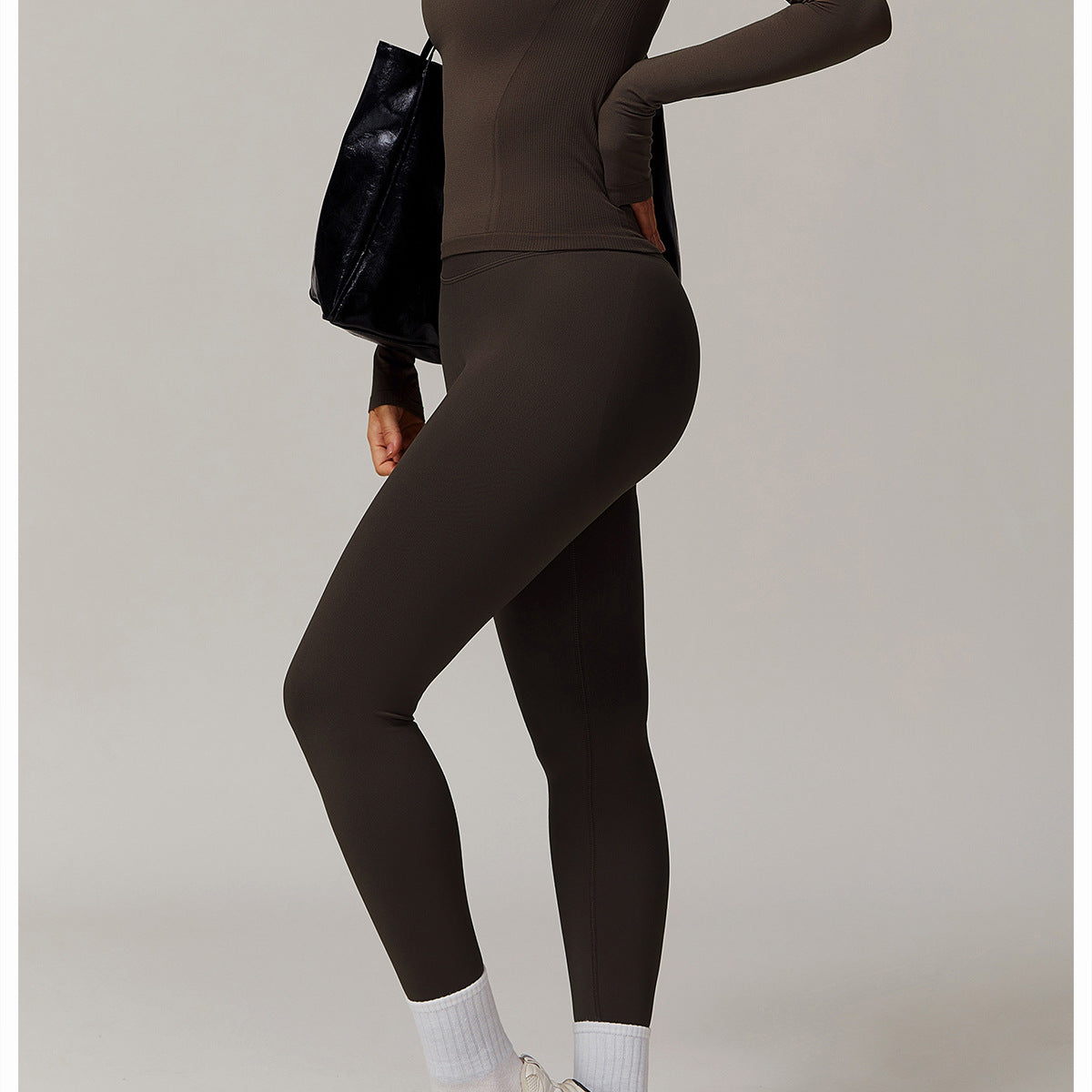 Olive-green long sleeve running top with white socks and sneakers in stylish athleisure fashion