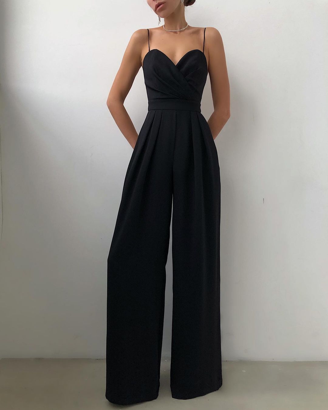 Elegant black wide-leg jumpsuit with spaghetti straps, perfect for modern fashion ملابس