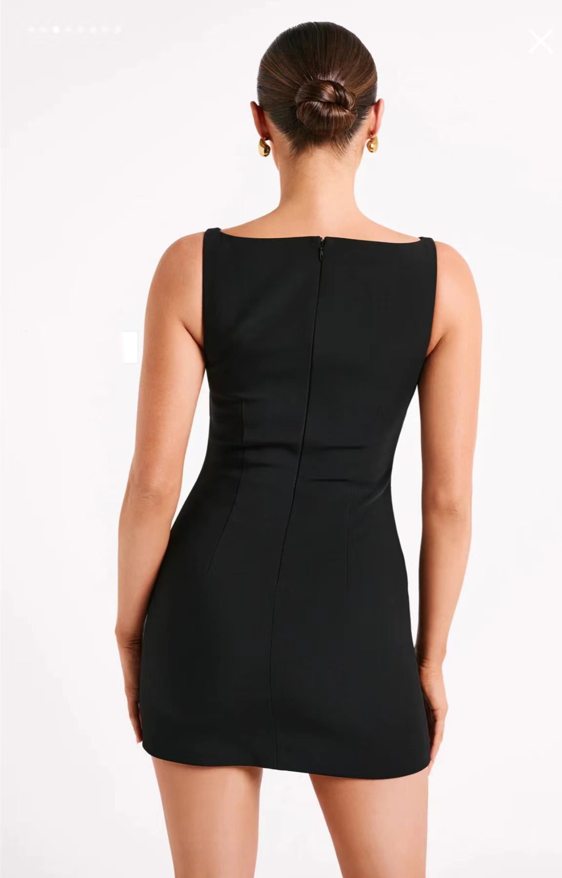 Back view of a sleeveless black mini dress showcasing elegant fashion styling
