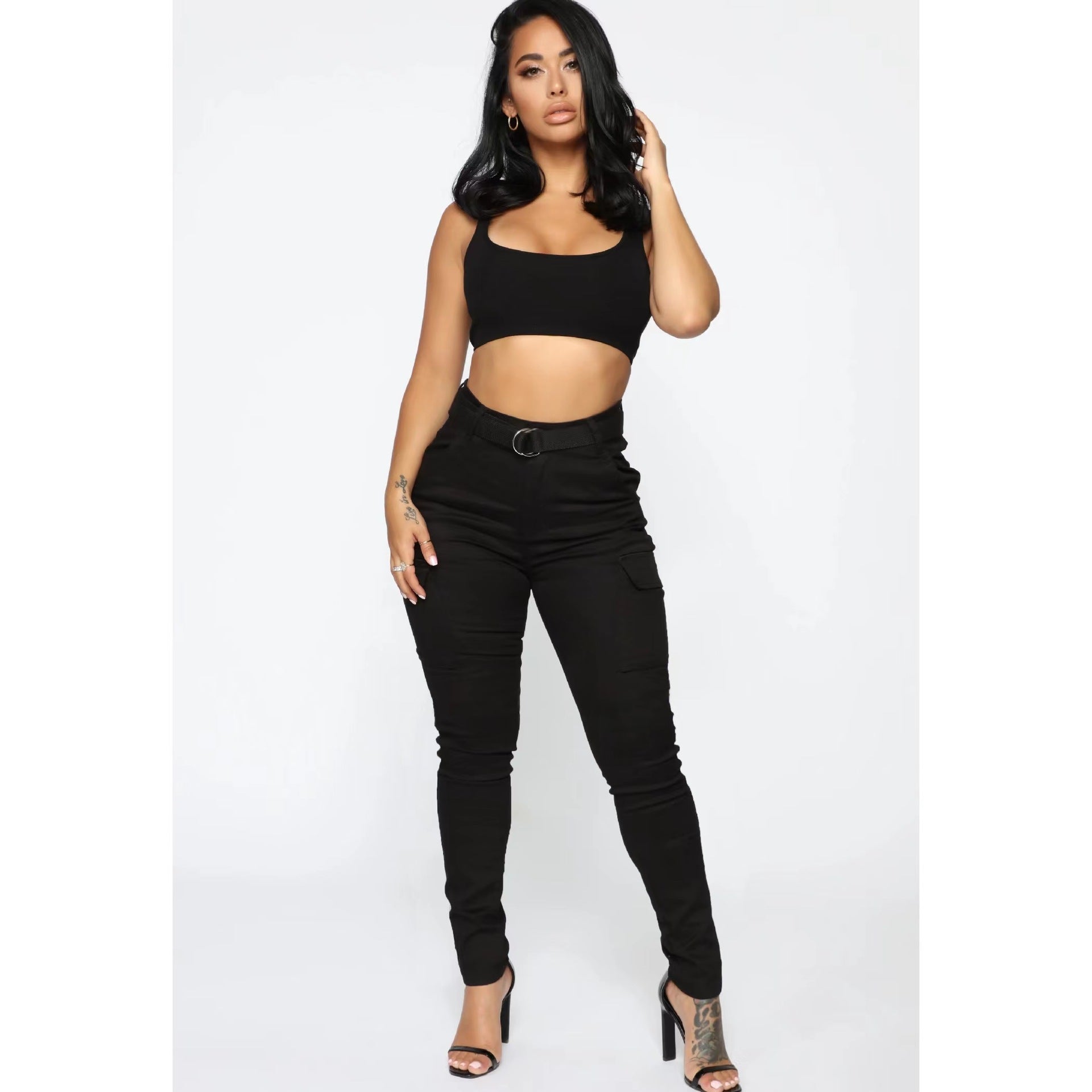 Woman in black crop top and pants showcasing casual skinny stretch belt sports pants