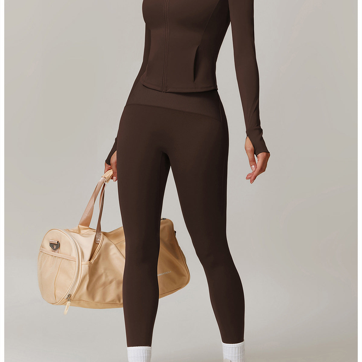 Brown long-sleeved turtleneck jumpsuit with leggings, styled with white socks and chunky sneakers in fashion ملابس