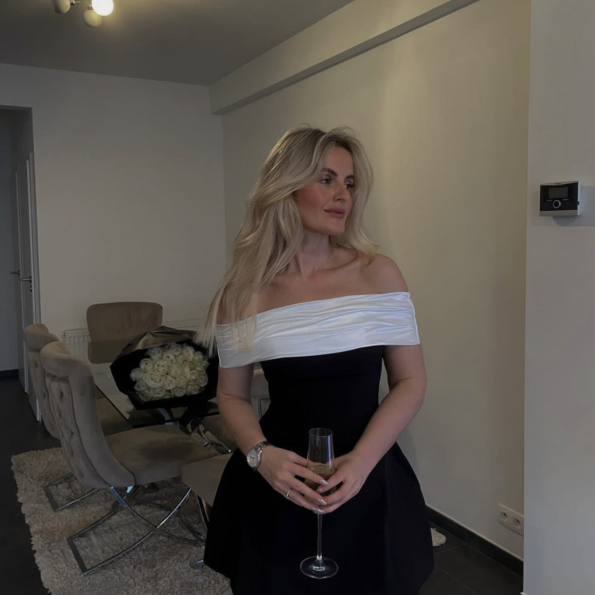 Elegant woman in Black White Swing Design Bow Dress holding champagne showcasing fashion style