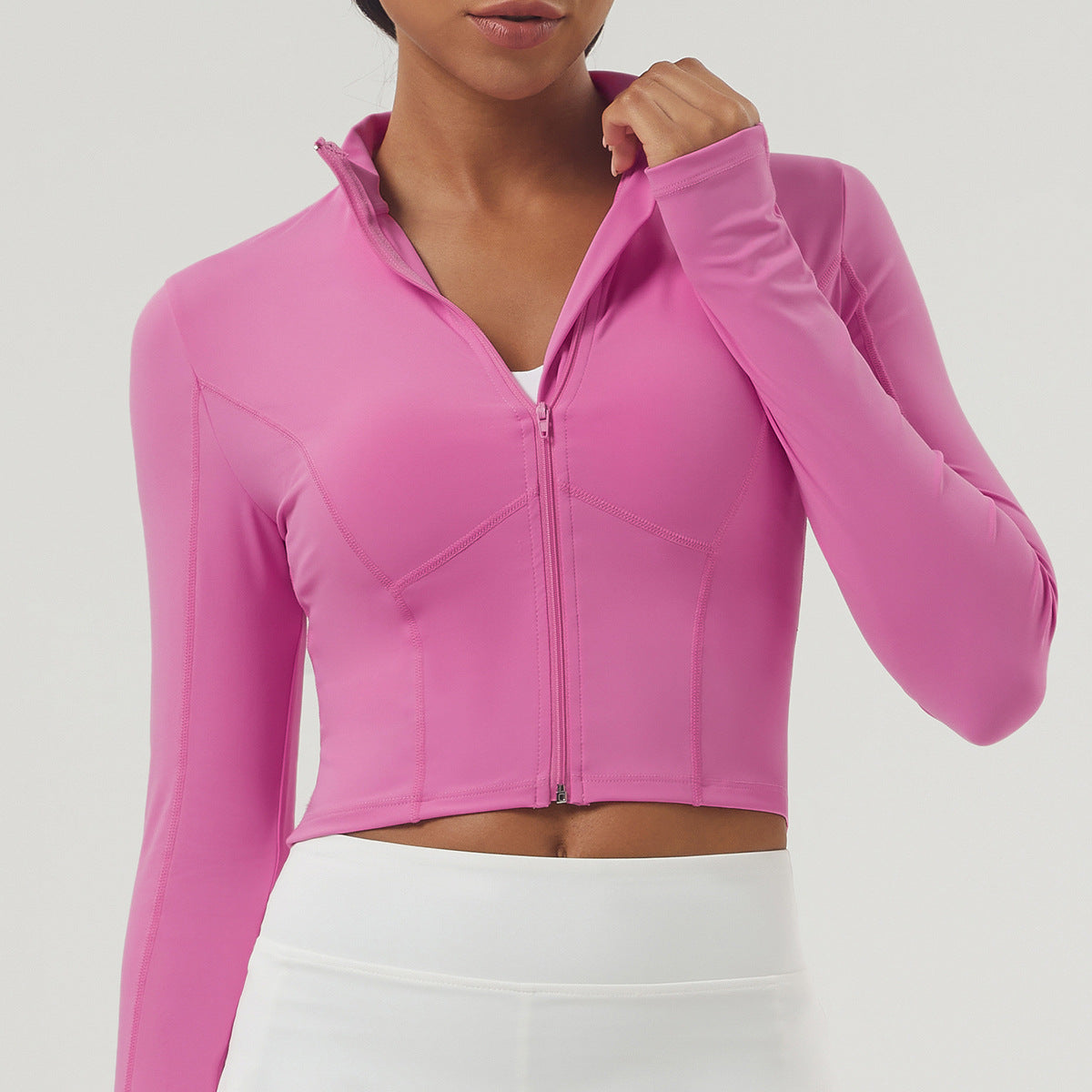 Bright pink long sleeve athletic crop top with full-zip front, ideal for fashion and sports