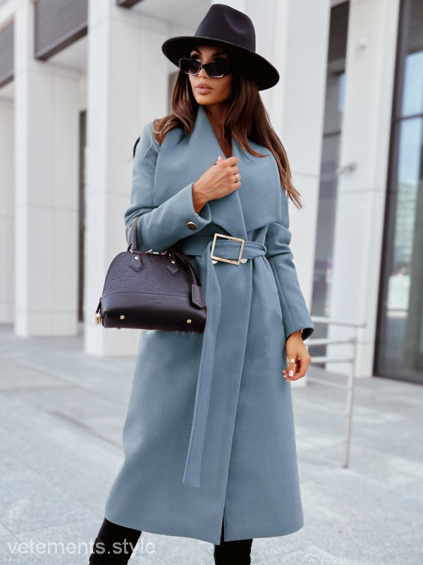 Woman wearing an elegant button coat with long sleeves and a black hat