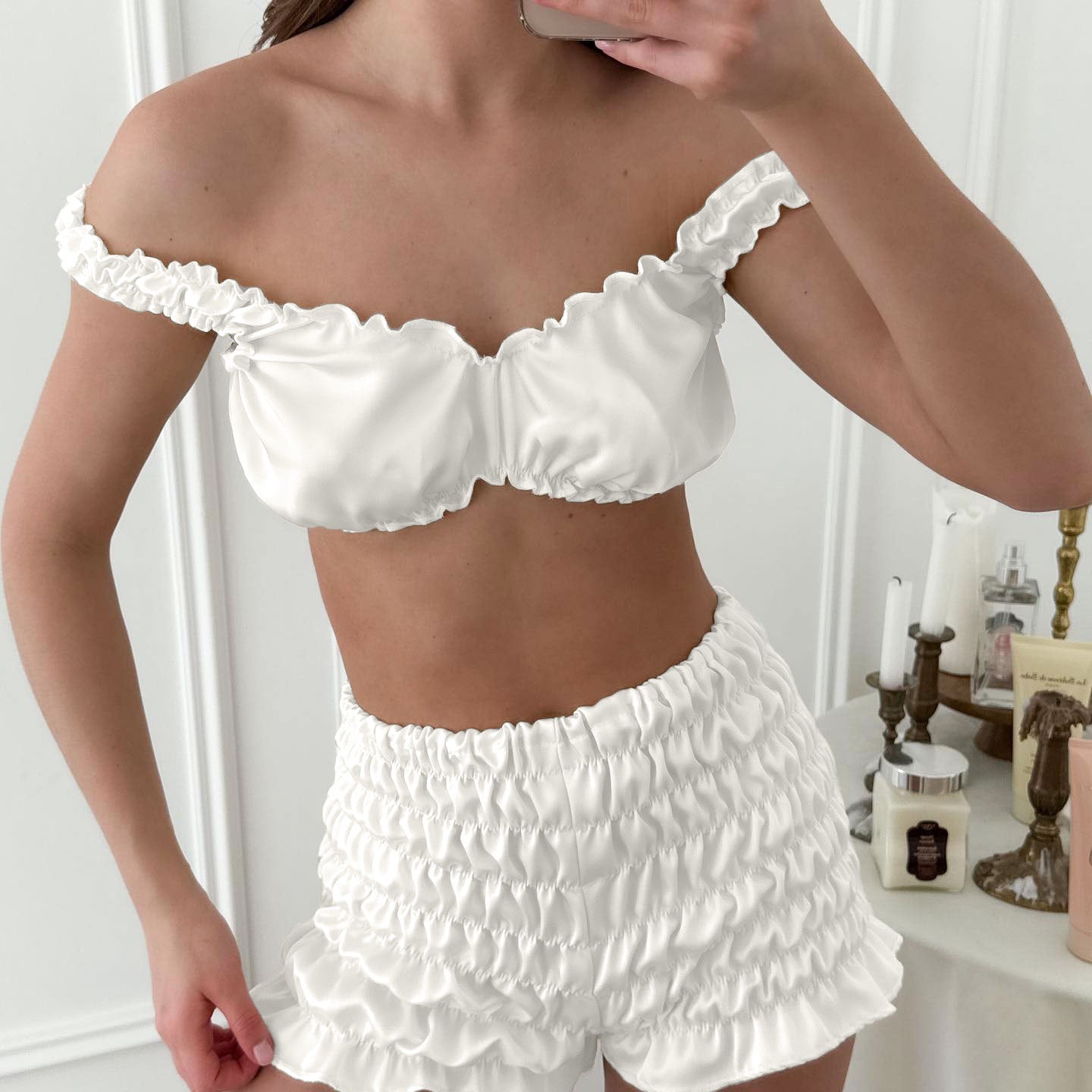 White ruffled off-shoulder pleated satin crop top and shorts set with lace trim