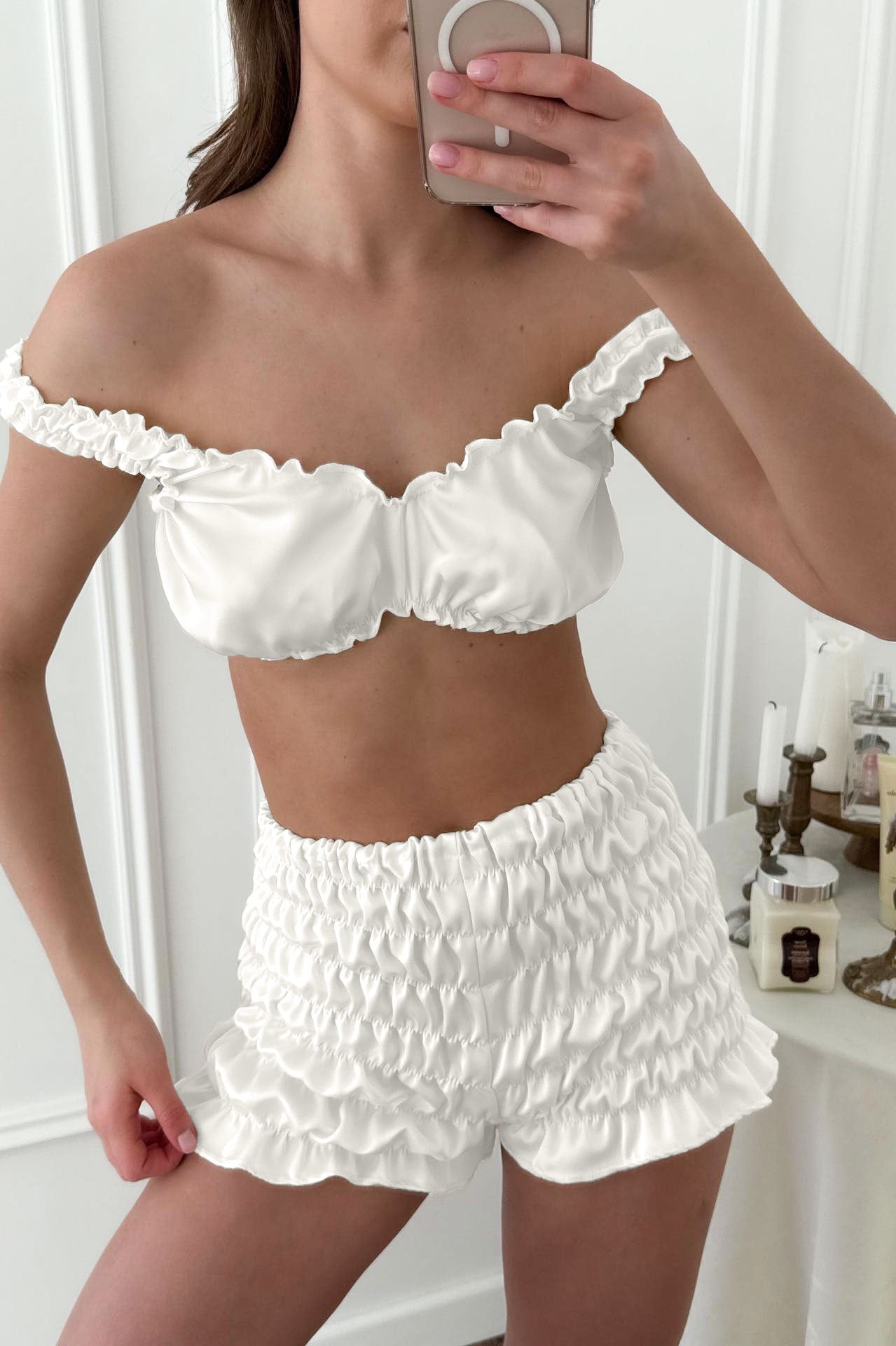 White ruffled off-shoulder pleated satin crop top and shorts set with lace trim