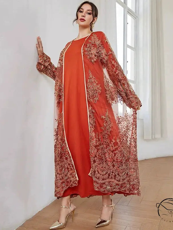 Woman in vibrant orange langry fashion mesh dress with gold embroidery