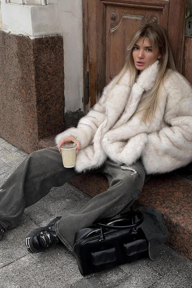 Fashionable faux fur coat with black leather satchel