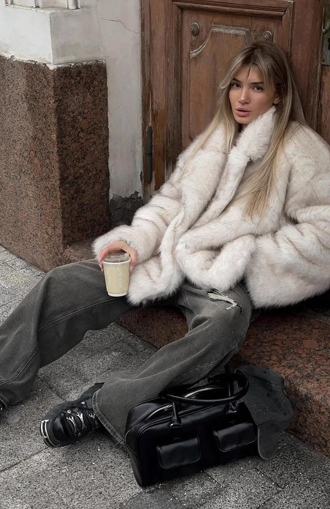 Fashionable faux fur coat with black leather satchel