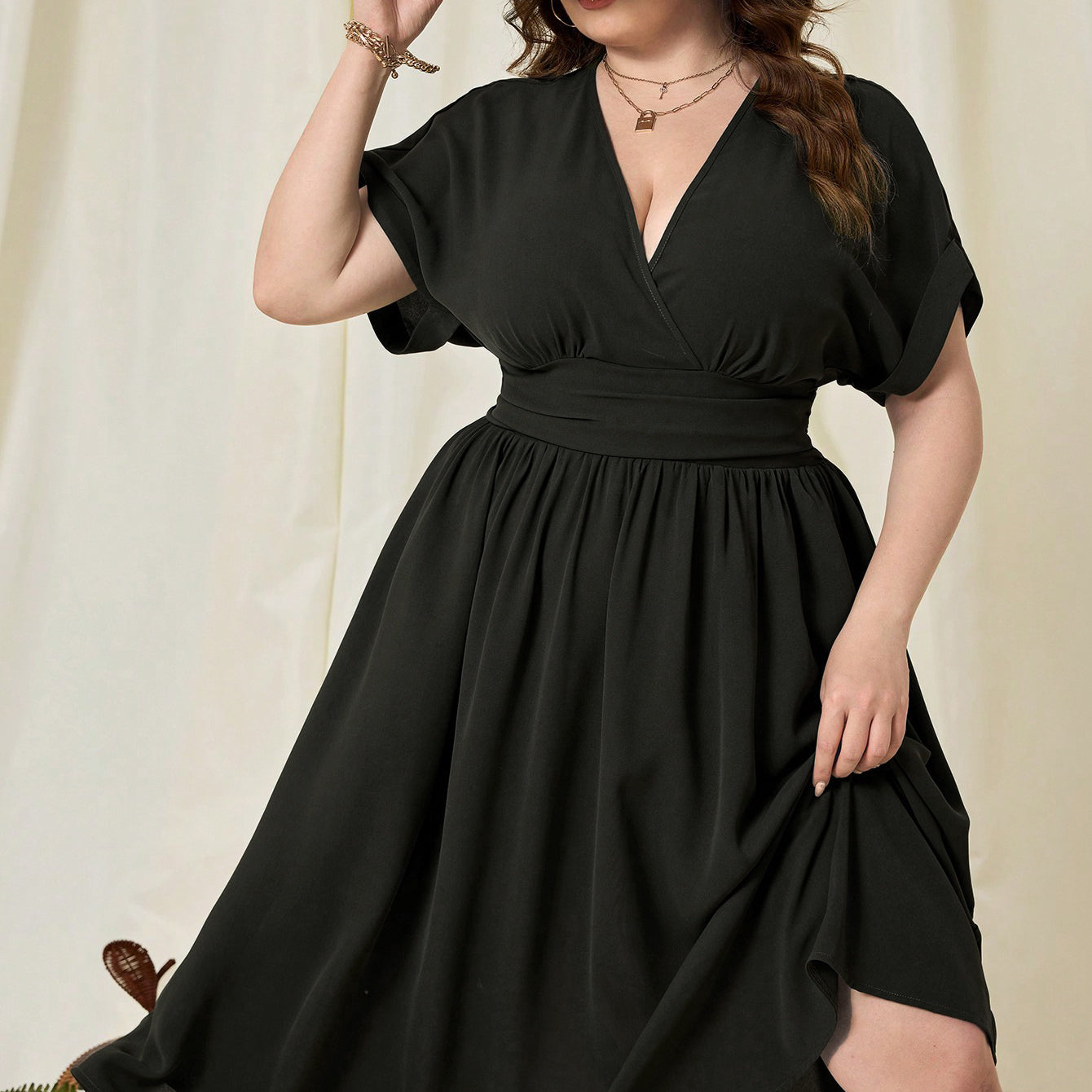 Plus-size woman wearing a black high waist vacation high midi dress with tied waist and wide-brimmed hat