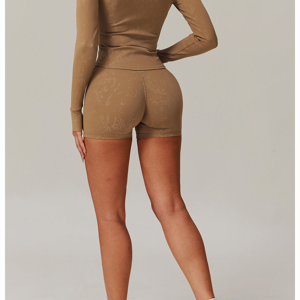 Woman in tan ribbed mock-neck top and high-waisted shorts, stylish langry fashion